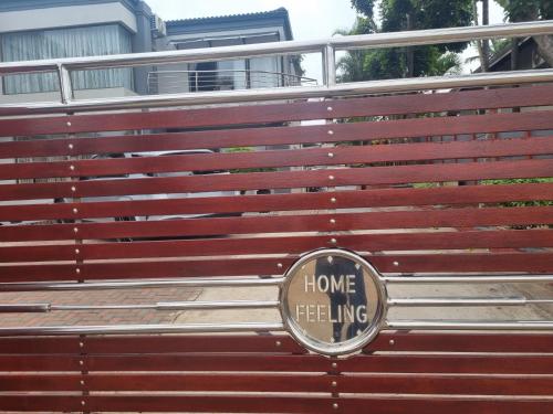 a home telling sign on the front of a bench at Home Feeling Guesthouse in Port Shepstone