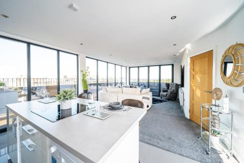 a kitchen and living room with large windows at Luxurious 2-Bedroom Penthouse Apartment with Stunning Glass-Wall Views in Barnsley Town Centre in Barnsley