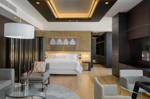 Habitación de hotel con cama y mesa de cristal en The Westin Doha Hotel & Spa en Doha
