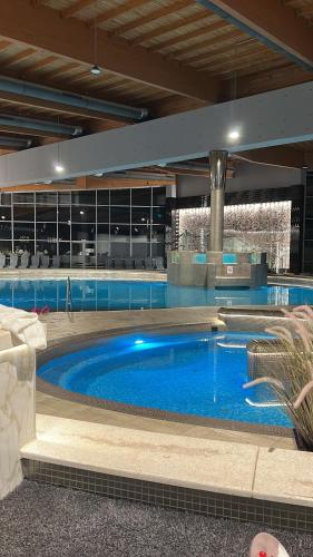 a large pool with blue water in a building at Azúr Port Siófok With Free Wellness in Siófok