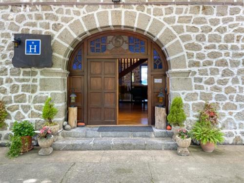 an entrance to a stone building with a wooden door at Hotel Arimune in Bakio