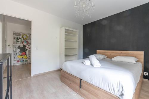 ein Schlafzimmer mit einem großen Bett mit weißer Bettwäsche in der Unterkunft Disneyland-Paris 4pers,Wifi, parking in Chessy