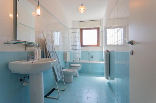 ein blaues Bad mit einem Waschbecken und einem WC in der Unterkunft Bright Apartment near Parco Dora by Wonderful Italy in Turin