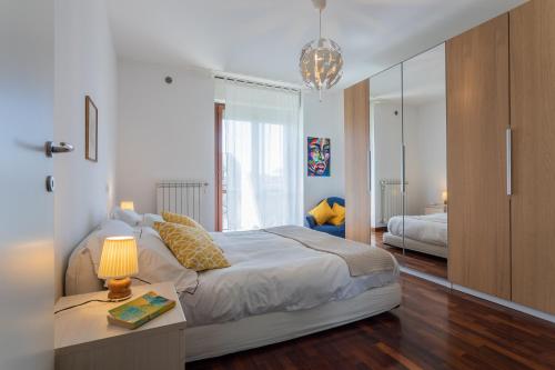 ein Schlafzimmer mit einem Bett und einem Tisch mit einer Lampe in der Unterkunft Bright Apartment near Parco Dora by Wonderful Italy in Turin