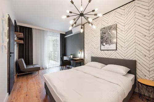 sypialnia z dużym białym łóżkiem i biurkiem w obiekcie Wola Grzybowska Industrial Apartment w Warszawie