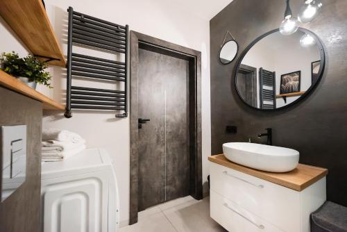 W łazience znajduje się umywalka i lustro. w obiekcie Wola Grzybowska Industrial Apartment w Warszawie