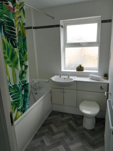 a bathroom with a tub sink and a toilet at Latchford Mews in Warrington