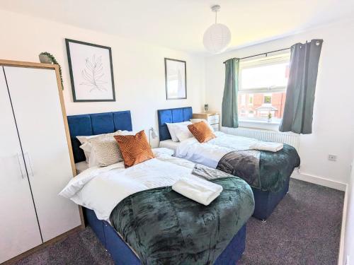 a bedroom with two beds and a window at Latchford Mews in Warrington