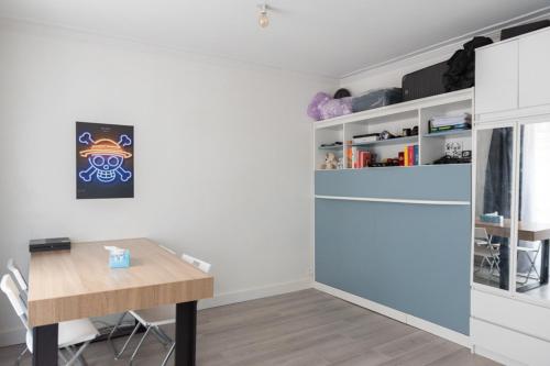 une salle à manger avec une table et un réfrigérateur dans l'établissement Charming studio near Parc Clichy, à Paris