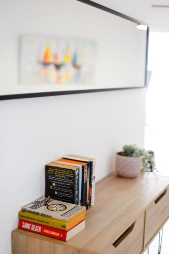 a pile of books sitting on top of a table at Daniel's Apt - Magical Views in Tsadha