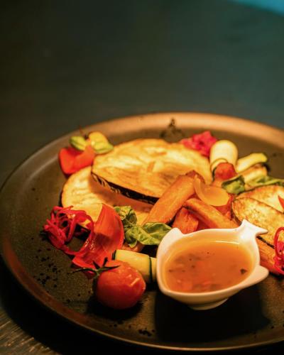 a plate of food with meat and vegetables and a dipping sauce at Hotel Lido Beach PHG in Oristano