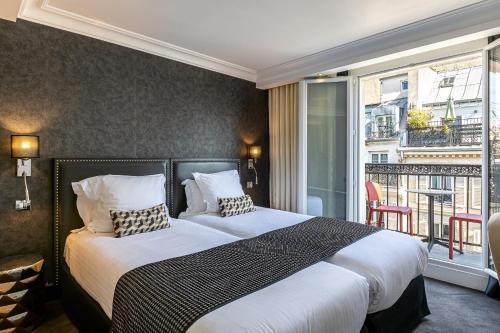 a bedroom with a large bed with a balcony at Hôtel Diva Opera in Paris