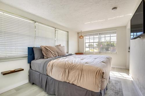 a bedroom with a bed in a room with windows at Fenced Yard and Hot Tub Pompano Beach Vacation Home in Pompano Beach