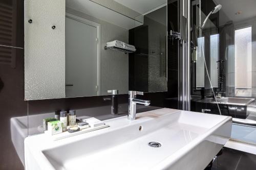a bathroom with a white sink and a mirror at Hôtel Diva Opera in Paris