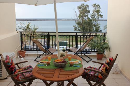 a table with a bowl of fruit on a balcony at Théa Apartment in Rethymno Town