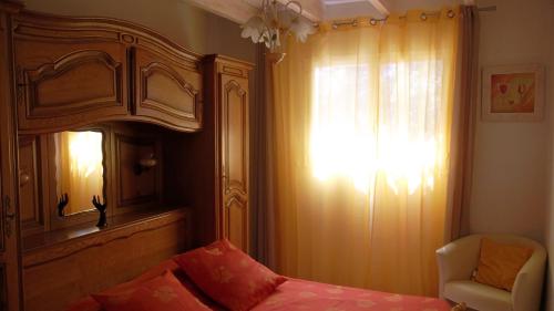 une chambre avec un lit, une fenêtre et une chaise dans l'établissement Villa Piscine-SPA vue grandiose., à Faugères