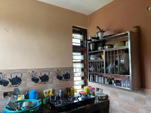 a kitchen with a counter with pots and pans on the wall at DHAULADHAR HOMESTAY PALAMPUR in Pālampur