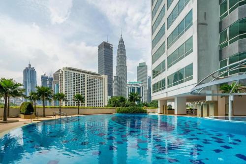 una grande piscina di fronte a uno skyline della città di ARH Home KLCC a Kuala Lumpur