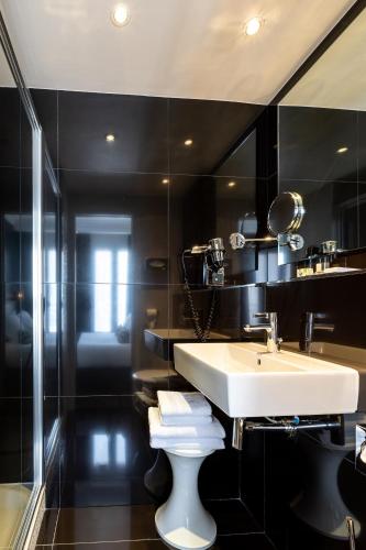 a bathroom with a sink and a mirror at Hôtel Diva Opera in Paris