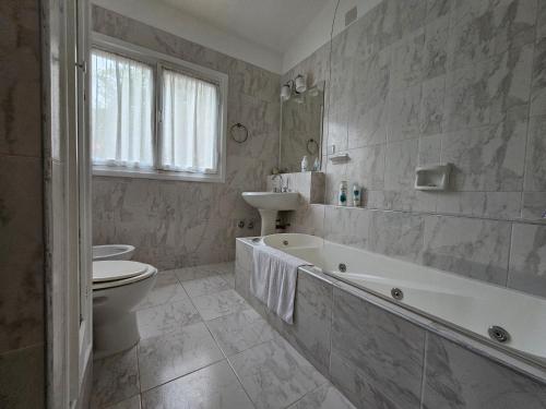 a bathroom with a tub and a toilet and a sink at Lo de Leo in Salta