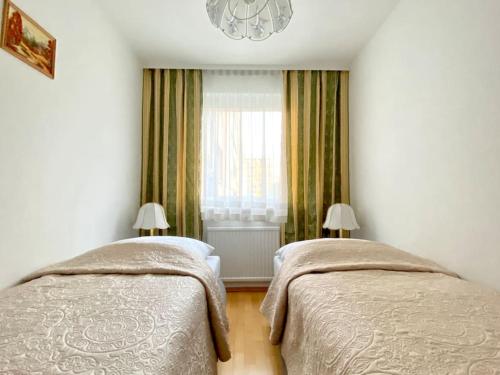 1 dormitorio con 2 camas y ventana en Near VIC Austria Center, 90sqm, 3BR, LR, Kitchen, 6min to VIC, 10min to City U1, en Viena