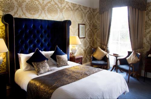 a bedroom with a large bed with a blue headboard at Royal Scots Club in Edinburgh