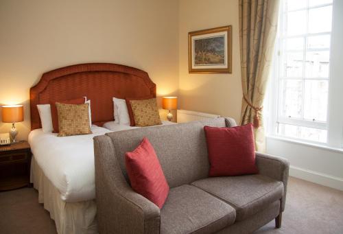 a bedroom with a bed and a couch and a chair at Royal Scots Club in Edinburgh