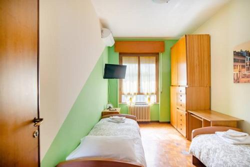 Cette petite chambre comprend 2 lits et une fenêtre. dans l'établissement Rozzano Humanitas Forum IEO, à Rozzano