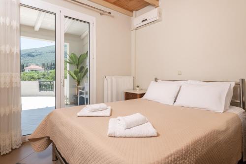 a bedroom with a large bed with two towels on it at Zamor Family Villa 1 in Mouzákion