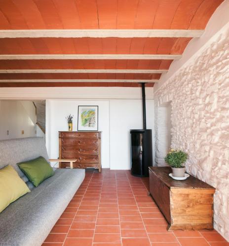 a living room with a couch and a brick wall at Ca la Carolina in Rabós