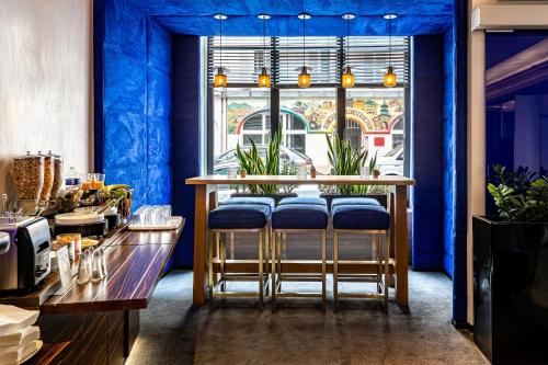 a restaurant with blue walls and a bar with blue stools at Hôtel Diva Opera in Paris