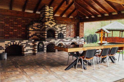 una cocina al aire libre con chimenea de ladrillo en una casa en Cabana Bombonel en Gura Teghii