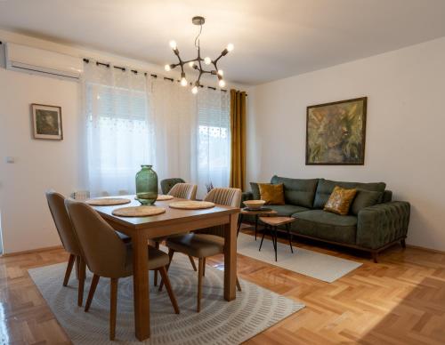 ein Wohnzimmer mit einem Tisch und einem Sofa in der Unterkunft Apartman Nest in Vranje