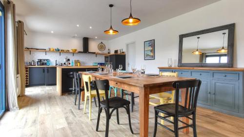 une cuisine avec une table en bois et quelques chaises dans l'établissement Grande villa 6 personnes à 200m de la mer . Récemment rénovée., à Moëlan-sur-Mer