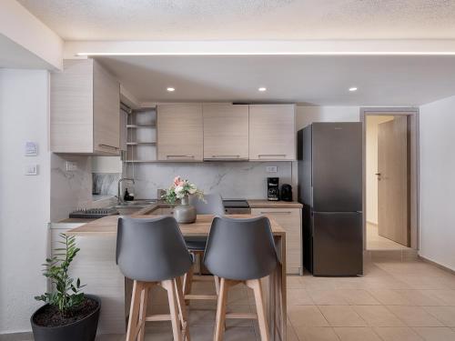 a kitchen with a refrigerator and a table with two chairs at Casa D'Irene Deluxe Hotel in Falasarna