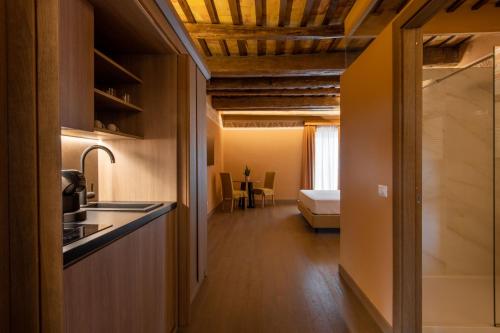 a kitchen with a sink and a room with a bed at Palazzo De Gregorio Apartments in Palermo