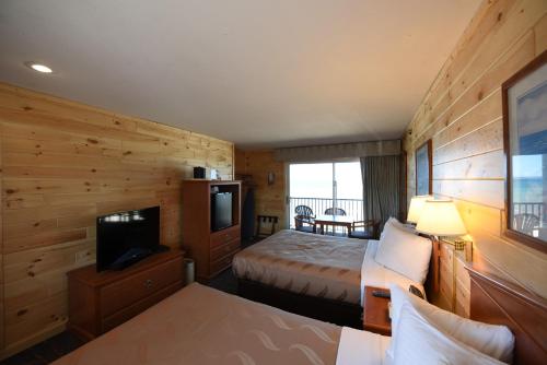a hotel room with a bed and a television at Quality Inn & Suites Beachfront in Mackinaw City