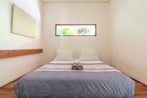 a bedroom with a bed with a pair of shoes on it at Private Pool Villa Retreat NAMU no4 no5 no6 in Kuta Lombok