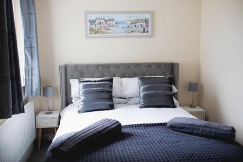 a bedroom with a large bed with blue pillows at Vanity Ballycastle Diamond 2 bedroom apartment in Ballycastle
