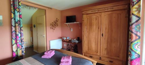 a bedroom with a bed and a wooden cabinet at La Grange de Champagnac in Yvrac-et-Malleyrand
