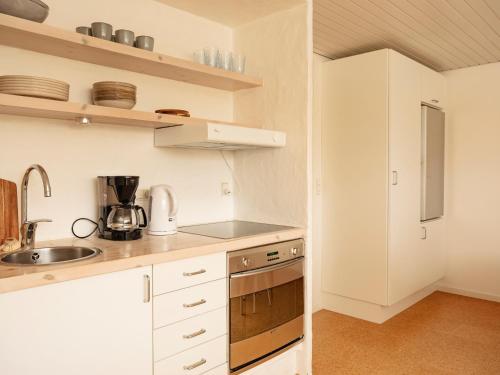 uma pequena cozinha com armários brancos e um lavatório em 2BR apartment / Tórshavn / 10min walk to city centre em Tórshavn