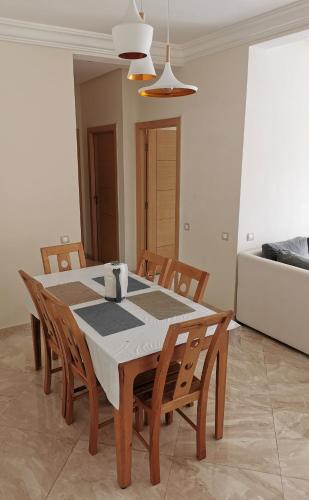 a dining room with a table and chairs at Casabay Appart Vue Sur Piscine in Sidi Rahal