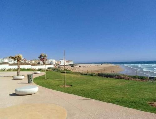 a sidewalk next to a beach with the ocean at sea view villa with garden in Agadir