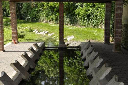 un reflejo de un banco en un cuerpo de agua en Café du lac en Manthes