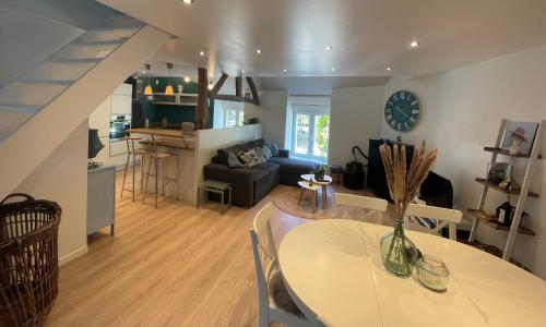 a living room with a dining room table and a kitchen at Gîte "Au Fourneau" in Spa