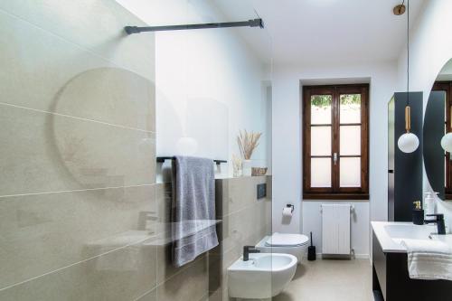 a white bathroom with a sink and a toilet at Agastache & Salvia - by MyHomeInComo in Menaggio