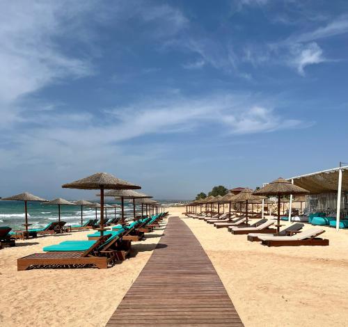 a row of chairs and umbrellas on a beach at Sea View Villa in Agia Thekla in Ayia Napa