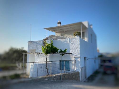 a white building with plants on top of it at Zefiria Countryside Cottage in Zefiría