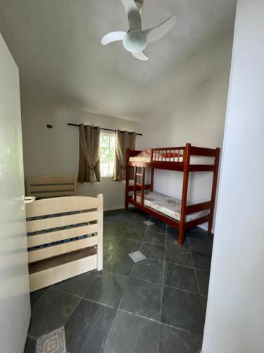 1 Schlafzimmer mit 2 Etagenbetten und einem Deckenventilator in der Unterkunft Casa de praia em Riviera no Módulo 21 in Bertioga