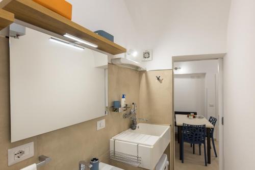 a bathroom with a white sink and a table at Coral - 30 passi dalla Spiaggia della Purità in Gallipoli